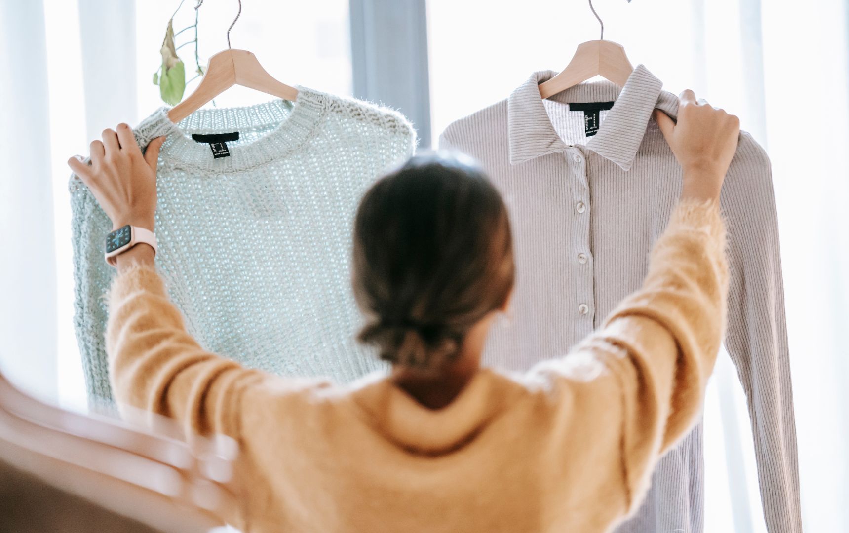Woman Trying to Decide Between Two Tops While Clothes Shopping